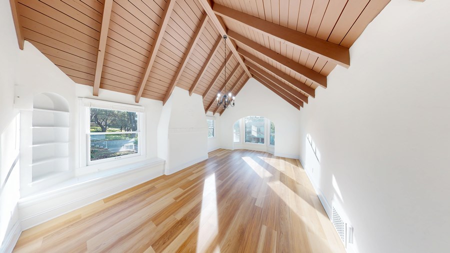 A room with wooden floors and a wooden ceiling with a window.
